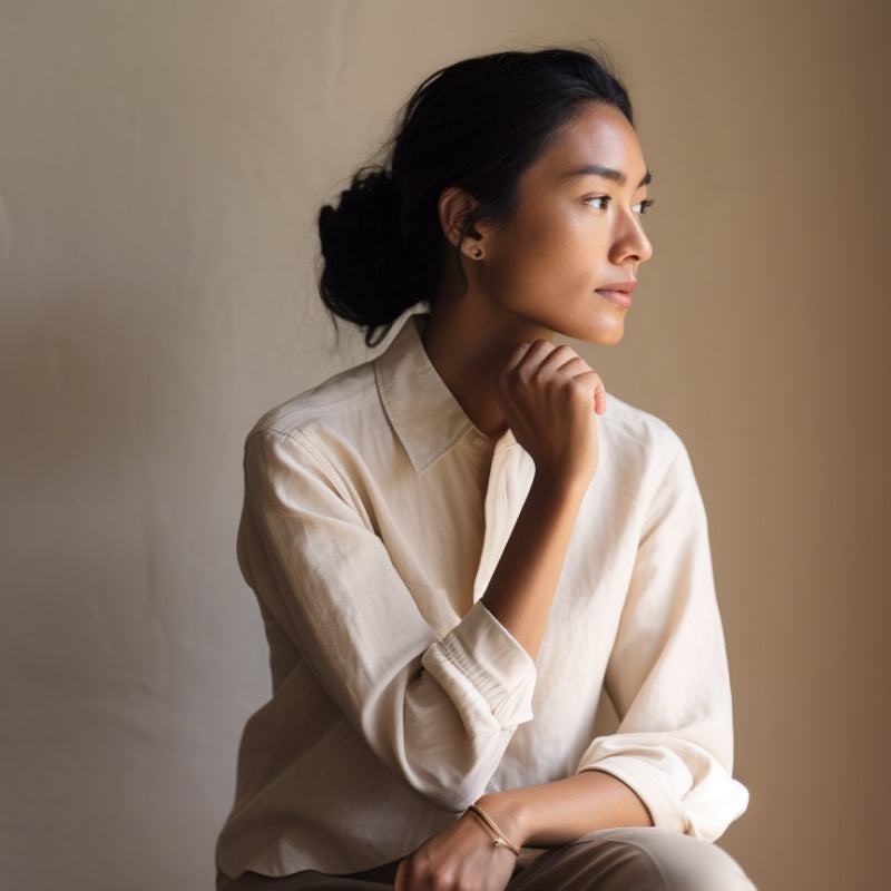 Woman in her mid 30s looking into the distance, reflecting on genetic conditions